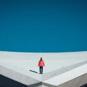 a man standing on a crazy rooftop in berlin , looks like on top of a snowy mountain
